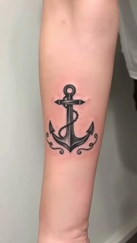 A classic nautical anchor tattoo on a forearm.