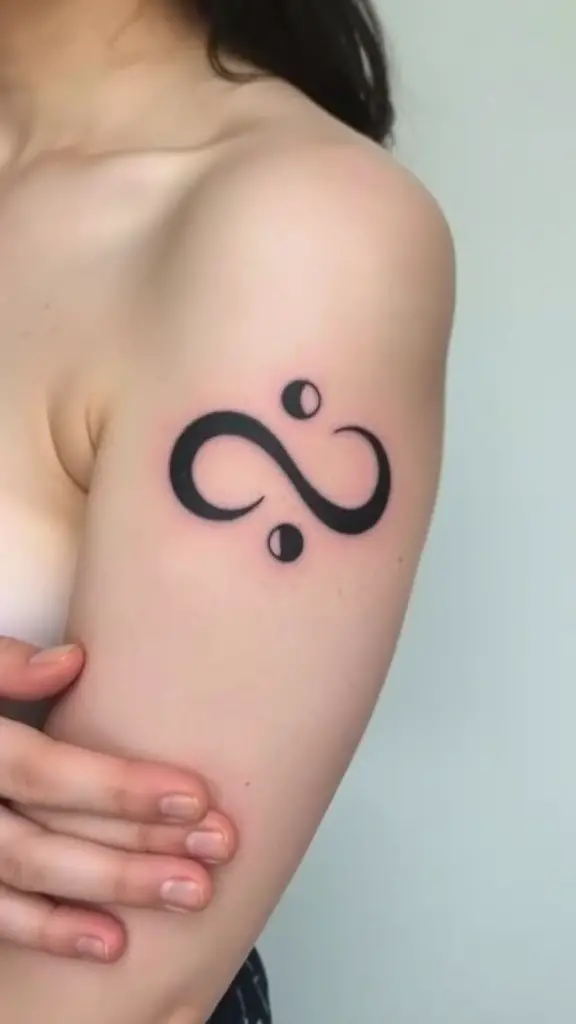 Infinity symbol tattoo with moon phases on the arm